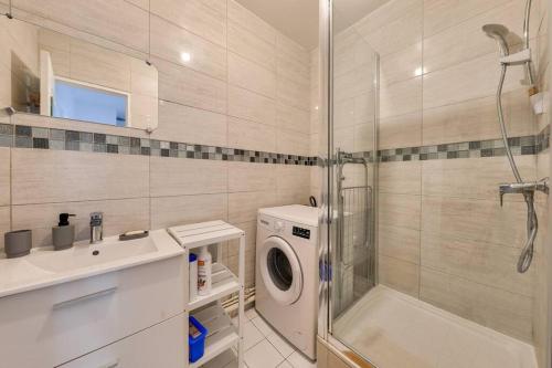 y baño con lavadora y ducha. en Le Boho Zen - spacieux F3 avec parking proche Paris, en Épinay-sur-Seine