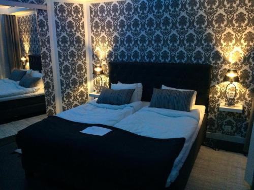 1 dormitorio con 2 camas con luces en la pared en Skänninge stadshotell en Skänninge