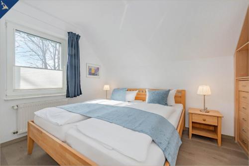 a bedroom with a large bed and a window at Ferienanlage Seeblick Aquamarin in Ostseebad Koserow