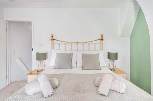 una camera da letto con un grande letto bianco con due lampade di Puddle Duck Cottage a Cranswick