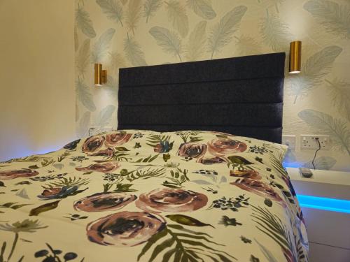 a bed with a bedspread with roses on it at Modern En-suite Doubles in Boston Town Spacious & Contemporary Rooms in Boston