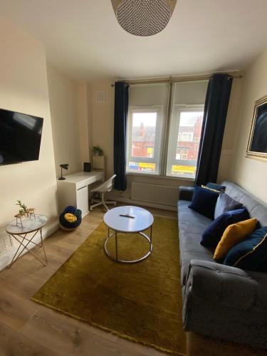 1 bed Flat ''Beta'' in Dewsbury road, Leeds في Hunslet: غرفة معيشة مع أريكة وطاولة