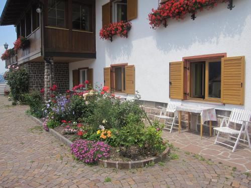 a house with a flower garden in front of it at Garni Sonneck in Laion