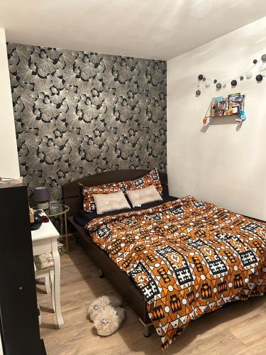 une chambre avec un lit et un mur dans l'établissement Eunila appart 15’ Défense, proche Paris, à Bezons