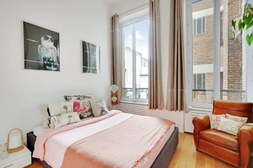 a bedroom with a bed and a chair and windows at Very nice apartment Atypical 6 People in Paris
