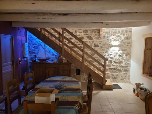 1 dormitorio con 1 cama en una pared de piedra en Les Forsythias en Messeix