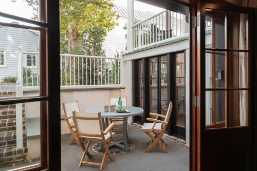un patio con tavolo e sedie sul balcone. di The Courtyard at CasaZoe a Charleston