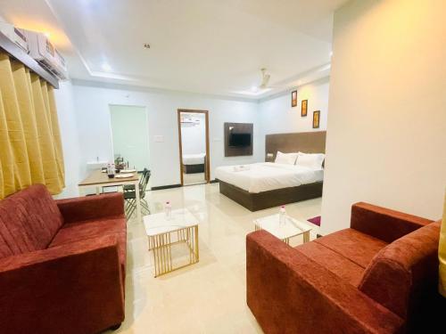 uma grande sala de estar com uma cama e um sofá em Deccan Suites, Tirupati em Tirupati