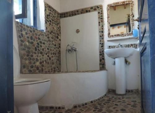 uma casa de banho com uma banheira, um lavatório e um WC. em Lovely independent room in Ecovilla on the beach em Apolakkiá