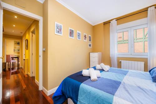 a bedroom with a blue bed with towels on it at GETXO II (Downtown, Beach and Parking) 15Min BILBAO By GrupoZTK in Getxo