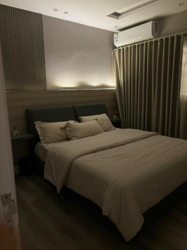 1 dormitorio con 1 cama blanca y ventana en Double Night, en Riad