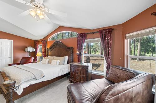 a bedroom with a bed and a couch and windows at Feather House | The Lost Sierra Ranch in Graeagle