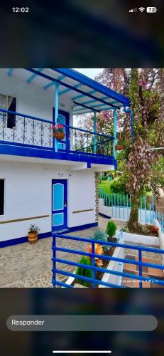 a picture of a house with a blue balcony at Vista Farallones Hostel in Jardin