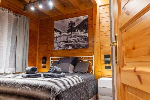 a bedroom with a bed in a wooden cabin at AndBnB l Junto a GrandValira con Parking Gratuito in Incles