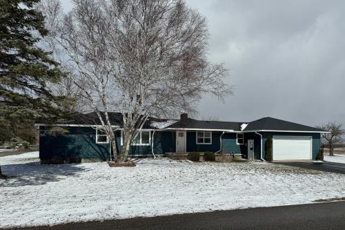 a house with a tree in the snow at Minutes from it All in Petoskey