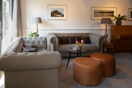 a living room with two couches and a table at Restaurant-Hotel de Watergeus in Noorden