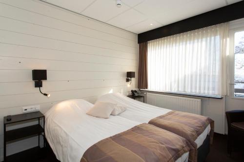 NoordenにあるRestaurant-Hotel de Watergeusのベッドルーム(大型ベッド1台、窓付)