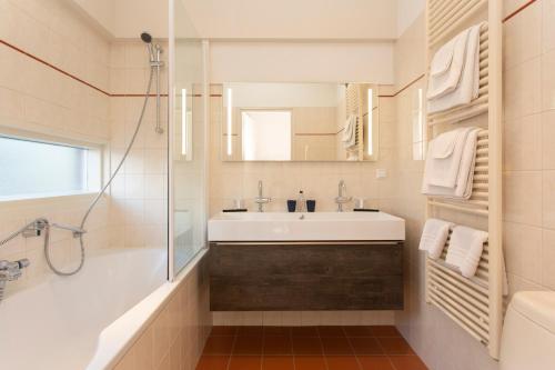 W białej łazience znajduje się umywalka i lustro. w obiekcie Restaurant-Hotel de Watergeus w mieście Noorden