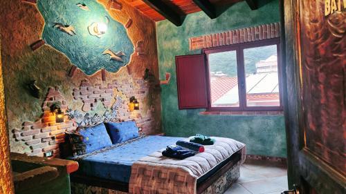 um quarto com uma cama com lençóis azuis e uma janela em Casa Gaudi em Teulada
