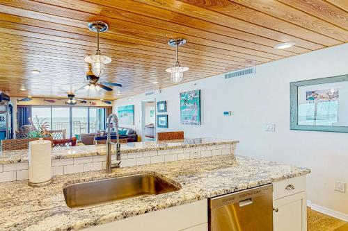 uma cozinha com um lavatório e uma sala de estar em Shore House 401 em Clearwater Beach