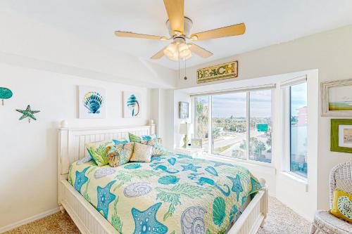 um quarto com uma cama e uma ventoinha de tecto em Shore House 401 em Clearwater Beach