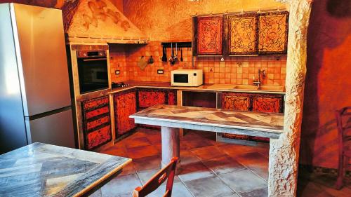 uma cozinha com uma mesa e um frigorífico em Casa Gaudi em Teulada