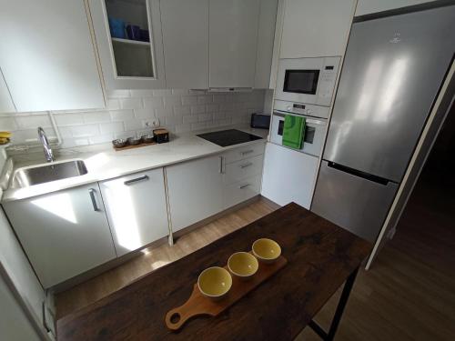 una cucina con tavolo in legno con due tazze sopra di Apartamento en Santander cercano al centro a Santander