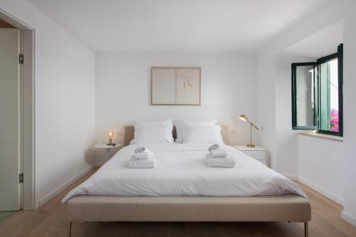 biała sypialnia z 2 ręcznikami na łóżku w obiekcie Beautiful Villa Schola with pool w mieście Trsteno