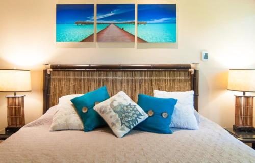 a bedroom with a bed with blue pillows at Happy Vibes Getaway with Stellar Oceanview Roof Pool! in Playa del Carmen