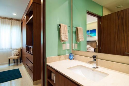a bathroom with a sink and a large mirror at Happy Vibes Getaway with Stellar Oceanview Roof Pool! in Playa del Carmen