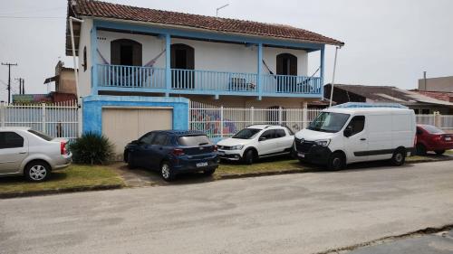 a group of cars parked in front of a house at Pousada paraíso no Mar in Matinhos