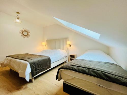 um quarto com duas camas e um telhado inclinado em Le Choiseul - T5 entre Loire et Château Royal - Manoir de la Concorde em Amboise