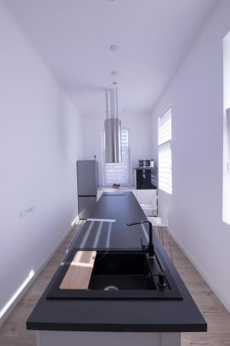 a kitchen with white walls and a black counter top at Wagner Villa 902 with free private parking in Budapest