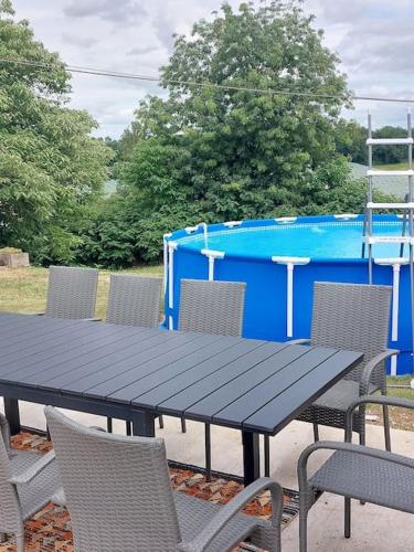 une table de pique-nique noire avec des chaises et un conteneur bleu dans l'établissement La grange de Rigounet, à Brassac
