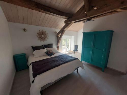1 dormitorio con 1 cama grande y armario verde en Villa pierre campagne en Brassac