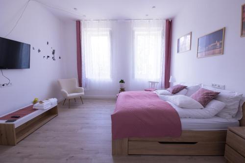 een slaapkamer met een groot bed en een roze deken bij Wagner Villa 902 in Boedapest