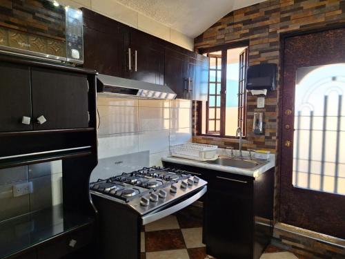 a kitchen with a stove and a sink at Bonita casa chica con amplio patio in Coatepec