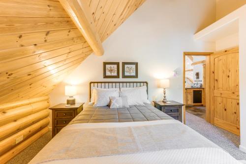 a bedroom with a large bed with wooden ceilings at Mountain Cabin with Hot Tub 4 Mi to Shaver Lake! in Shaver Lake