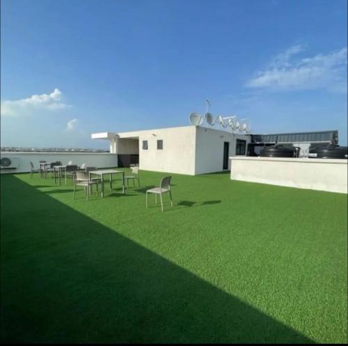 a lawn with chairs and tables on a building at Pine Court in Accra