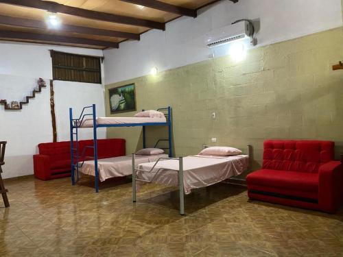 a room with two bunk beds and a couch at Holiday Home Mauras Tropical in Puntarenas