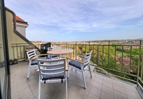 eine Terrasse mit einem Tisch und Stühlen auf dem Balkon in der Unterkunft Exclusive maisonette above the park in Prag