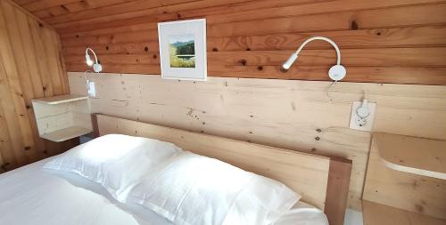 ein Schlafzimmer mit einem Bett in einer Holzhütte in der Unterkunft Apartment Jezerka in Cerknica