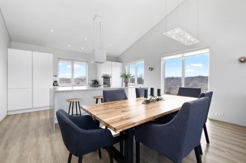 a kitchen and dining room with a wooden table and chairs at Luxury Villa in Golden Circle with hot tub in Selfoss