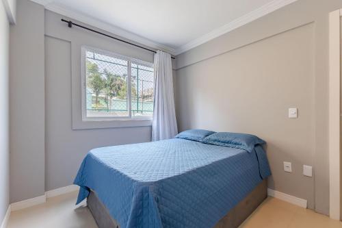 - une chambre avec un lit et une fenêtre dans l'établissement Apartamento em Bombas - Ótimo para Famílias, à Bombinhas