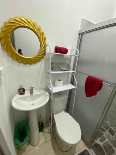 a bathroom with a sink and a mirror and a toilet at Casa Zion in San Juanillo