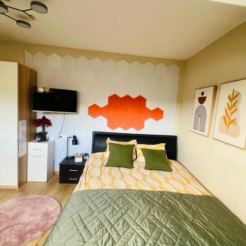 1 dormitorio con 1 cama con almohadas de color verde y naranja en SalzinnesChezSoi, en Namur