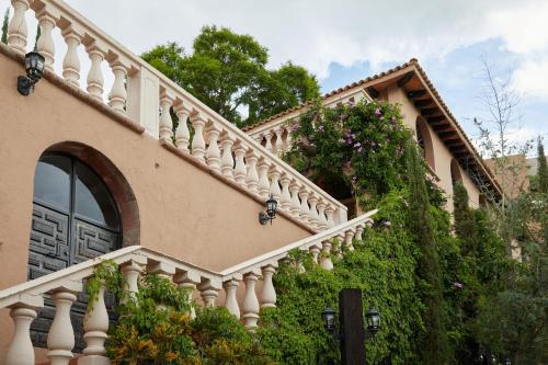 a house with a staircase with flowers on it at Casa Vista 6BR Villa, 16p Jacuzzi Pool, Staff & Breakfast in San Miguel de Allende