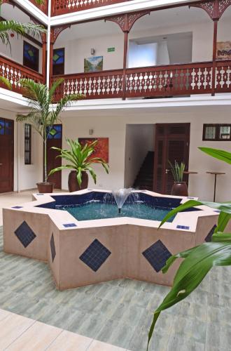 a pool in the middle of a building with a fountain at Maru Maru Hotel in Zanzibar City