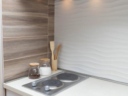 a kitchen counter with a stove top with wooden utensils at Apartment Kosta in Podgorica