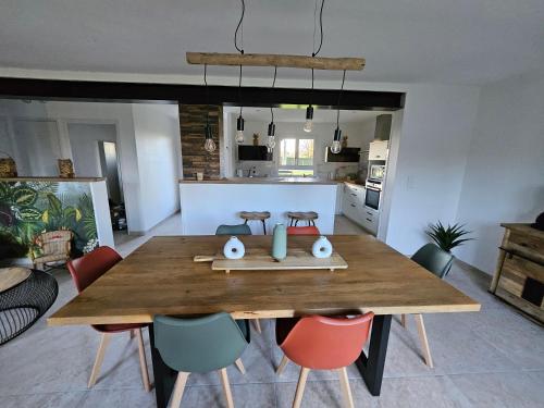 une cuisine et une salle à manger avec une table et des chaises en bois dans l'établissement Maison a la campagne, à Châteauvieux